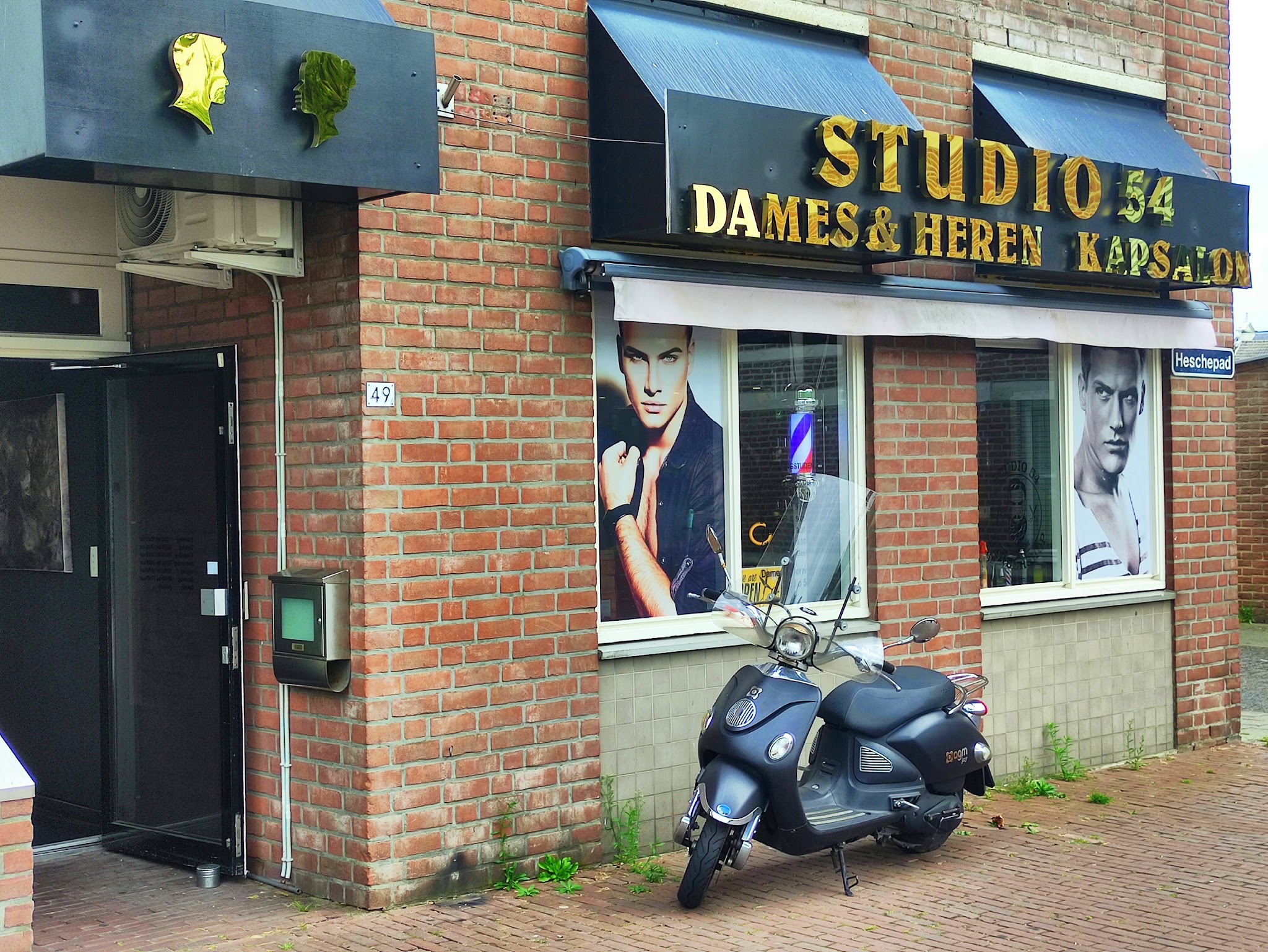 De voorkant van Studio 54 met de gouden letters STUDIO 54 DAMES & HEREN KAPSALON boven de ramen